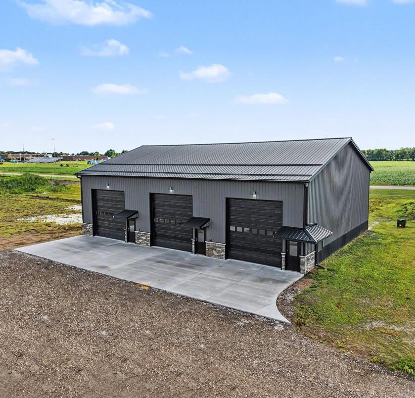 Building 1 exterior — three garage bays with stone wainscoting and black siding