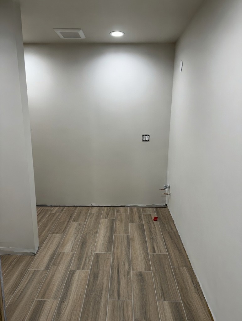 Design render — warm walnut-toned wood-look plank tile flooring