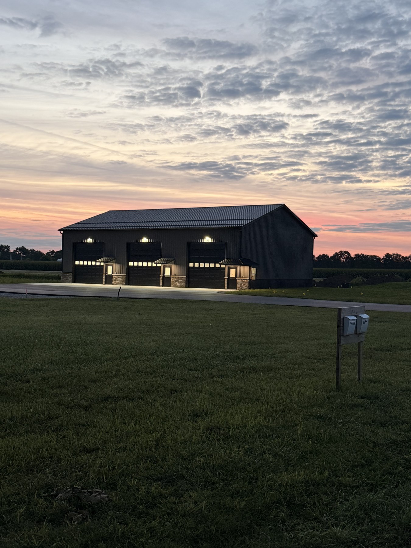Wide sunrise view of Building 1 with fresh asphalt parking lot and upgraded garage doors