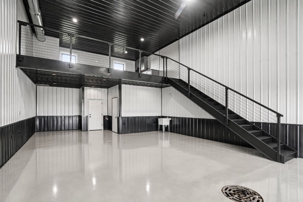 The Lake Bay wide bay view — polished floor, two-tone walls, mezzanine with black stairs and cable rail