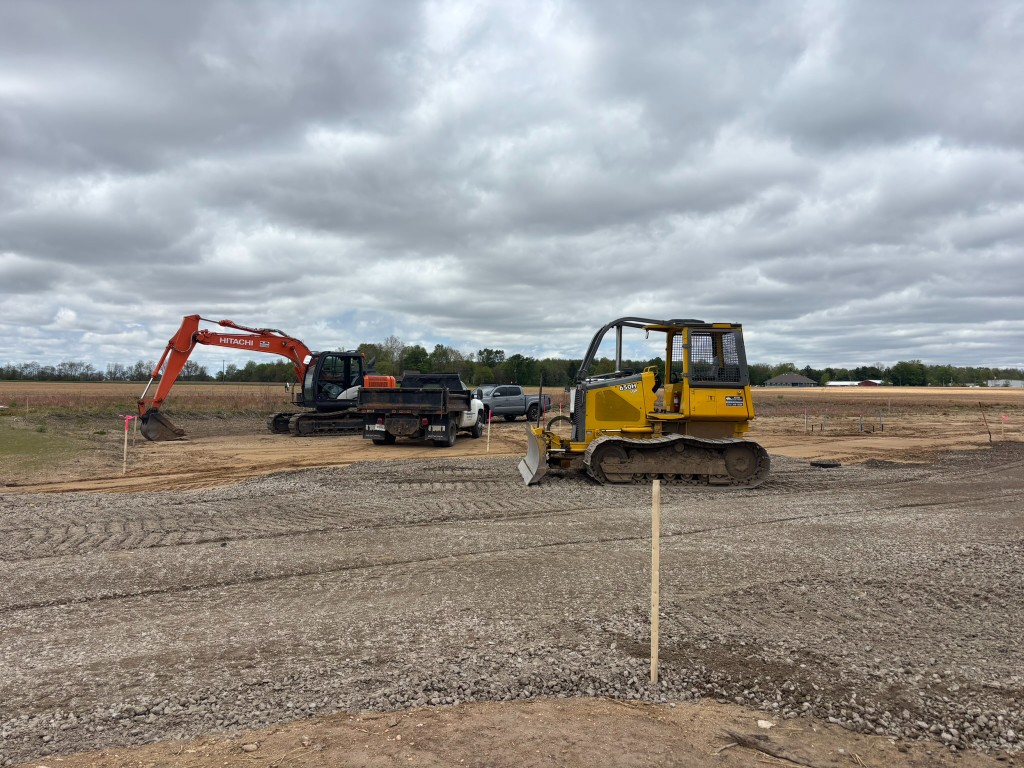 John Deere bulldozer and Hitachi excavator on the graded gravel base