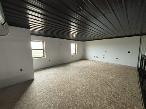 Mezzanine corner view — wide angle showing windows, black ceiling, and the full scale of the 384 sq ft platform
