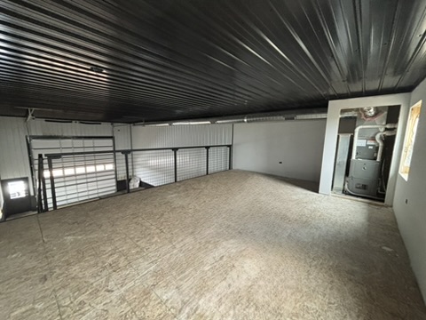 Mezzanine level — HVAC furnace closet, cable railing along the edge, OSB deck with black ceiling above