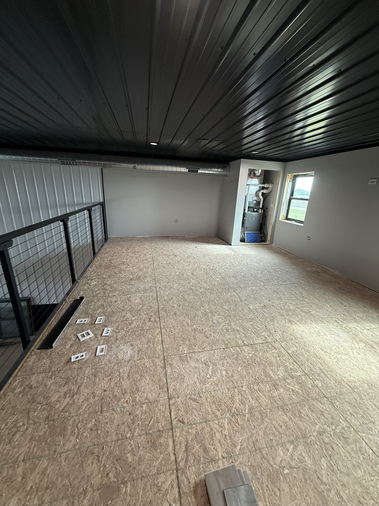 Full mezzanine view — 384 sq ft with cable railing overlooking the main floor, black corrugated ceiling, recessed lighting, and HVAC closet