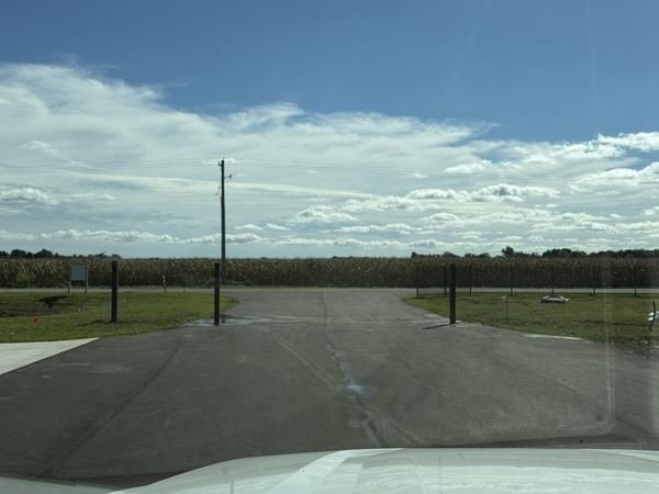 The drive running straight back toward the corn.