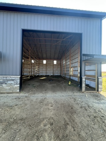 Building 1: open bay showing interior framing, insulation wrap, and scale
